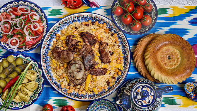 Traditional Uzbek feast with plov, non bread, salads, and tea